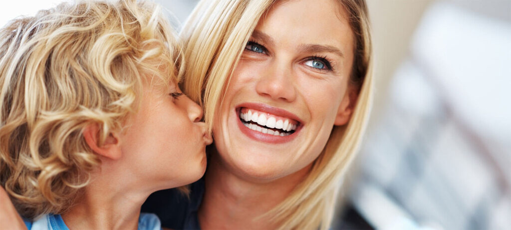 Young boy kissing smiling mom