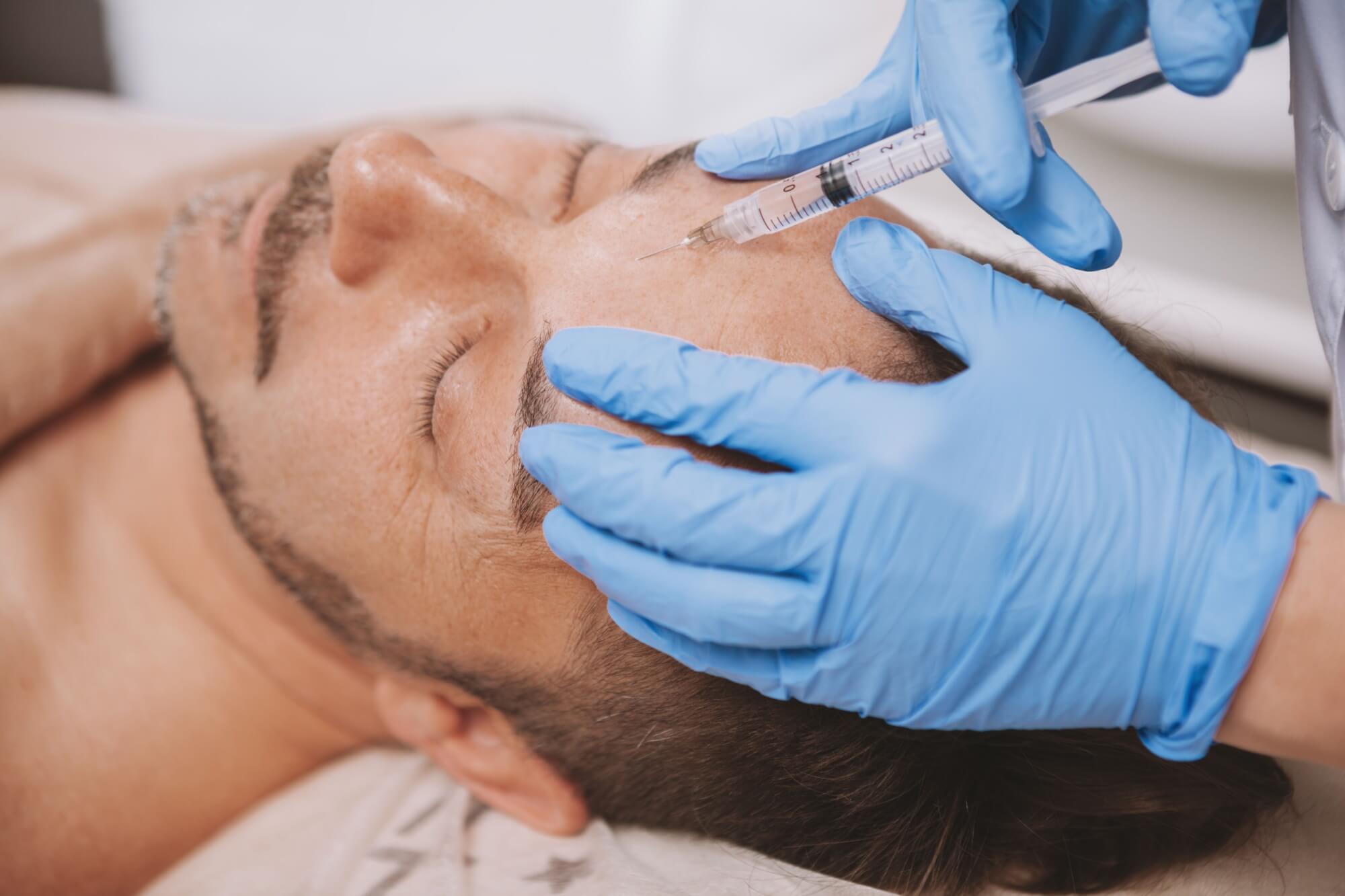 Mature man receiving facial filler injections