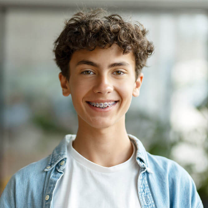 smiling smart curly haired school boy wearing braces