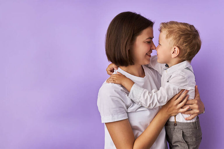 child boy touches the nose of mother