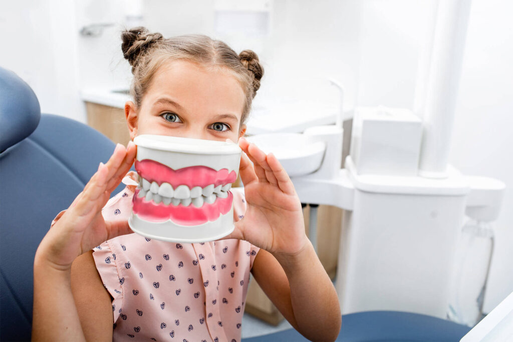 little girl sitting in the dentist's chair and smiling