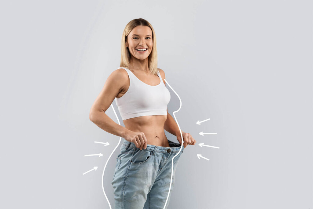 attractive slender middle aged blonde woman wearing huge jeans, showing results of diet