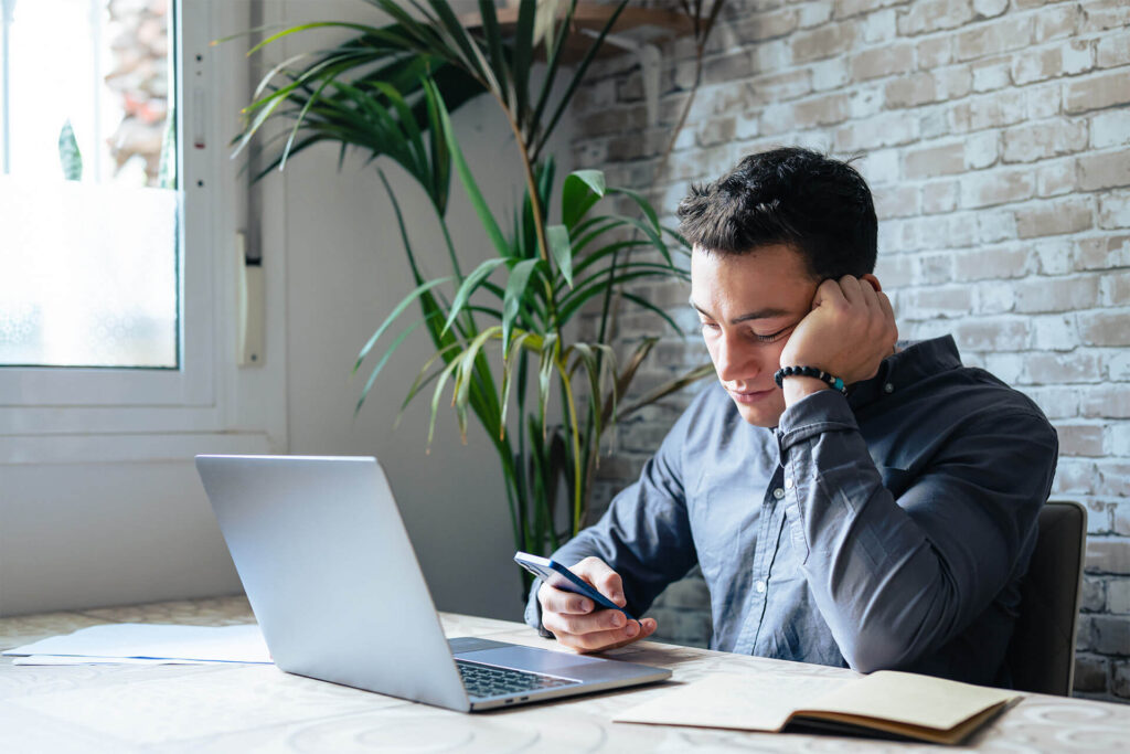 Unhappy young man looking at phone