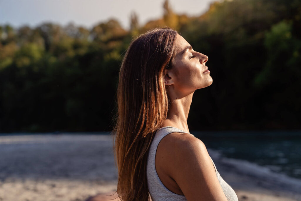 Young woman with long hair enjoying sun