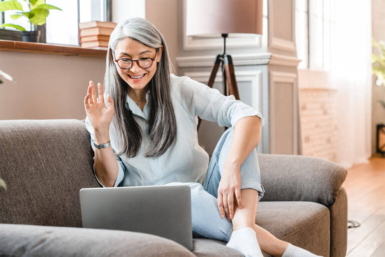 middle-aged woman having video call on laptop in the living room