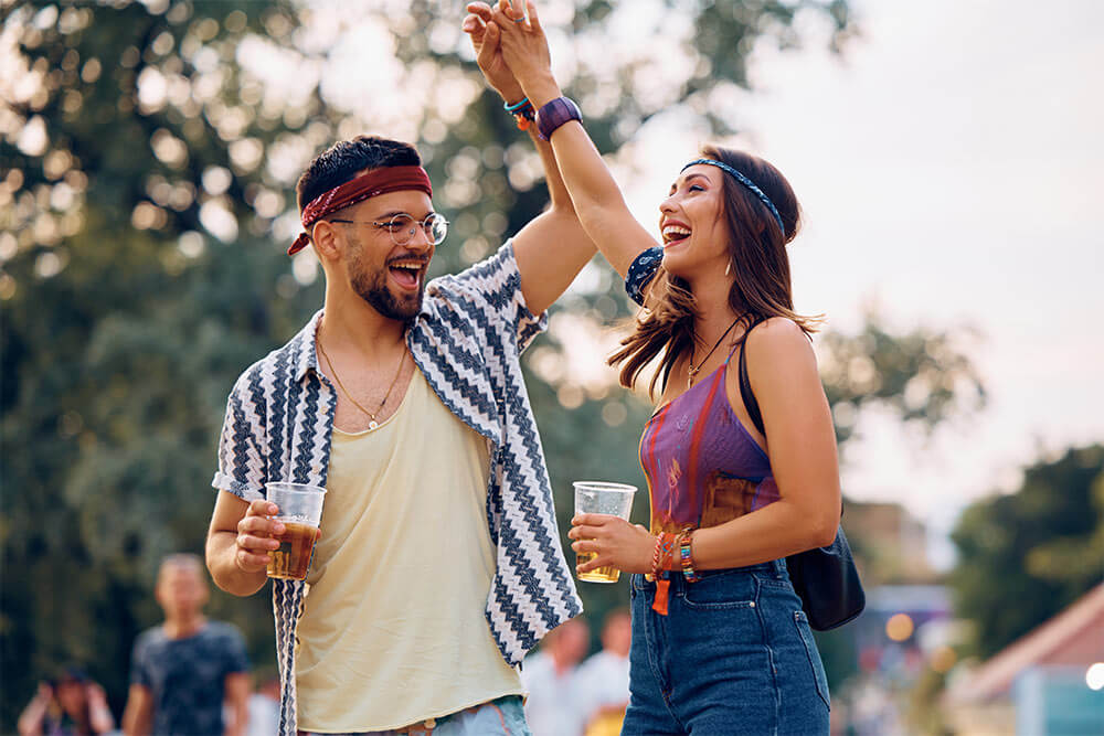 Carefree couple dancing and having fun at music concert.