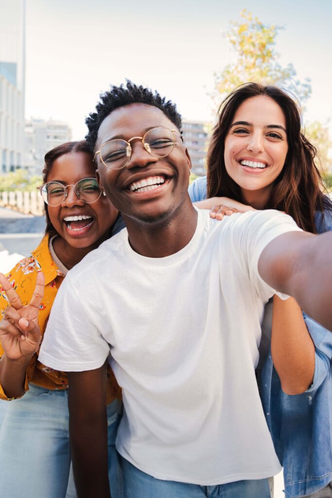 group of young people smiling taking a selfie together