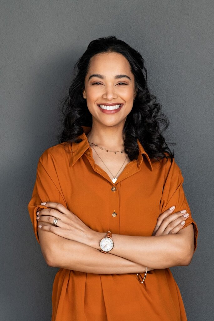 Young woman with pleasant smile and crossed arms