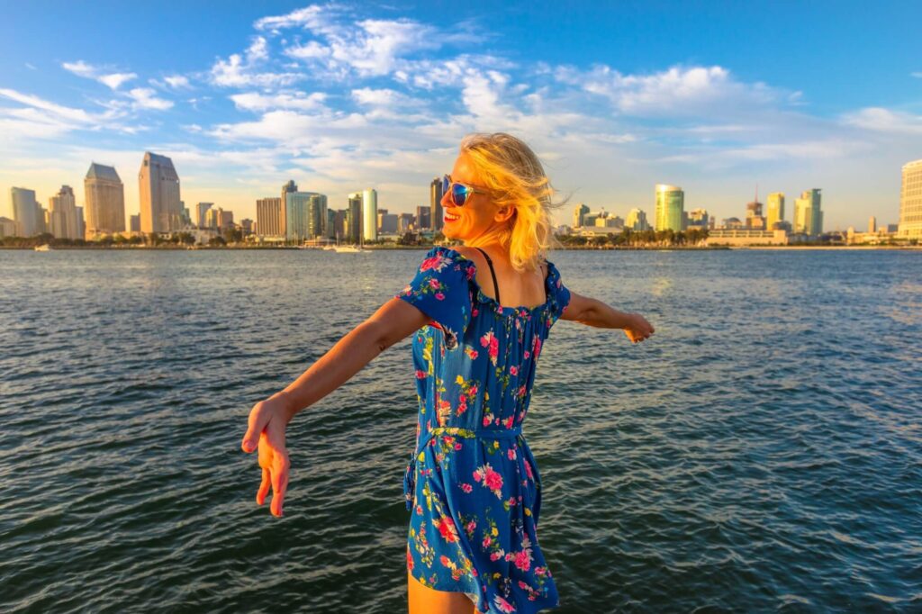 Happy tourist woman looking at Downtown skyline with skyscrapers