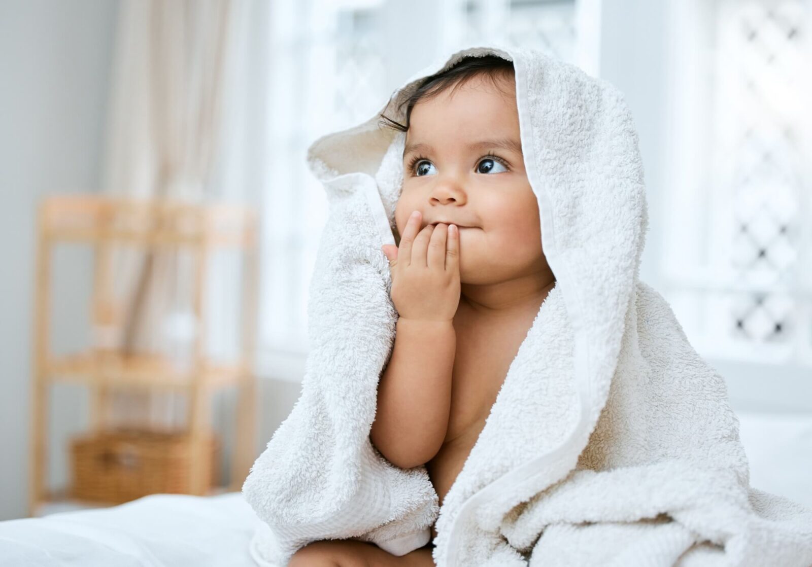 adorable baby covered in a towel after bath time