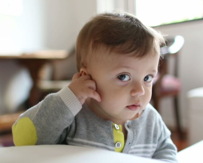 Adorable baby playing with ear