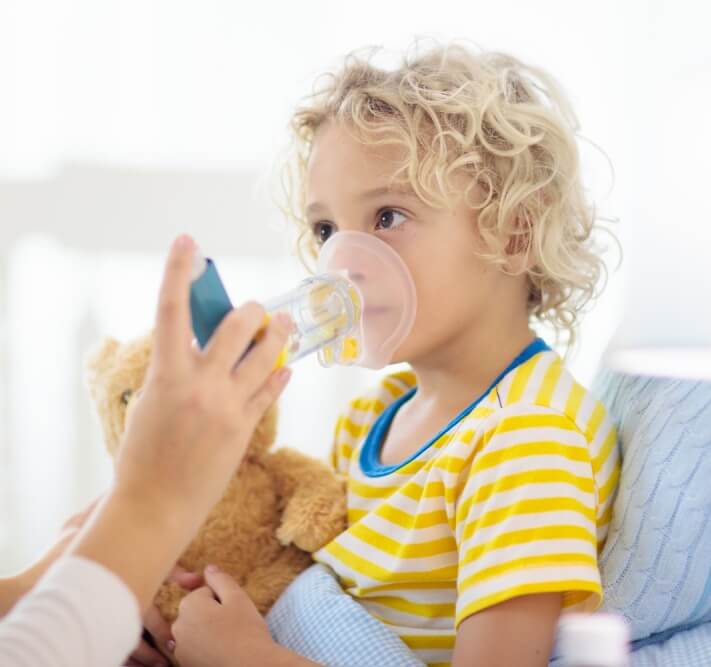 Sick little boy with asthma medicine