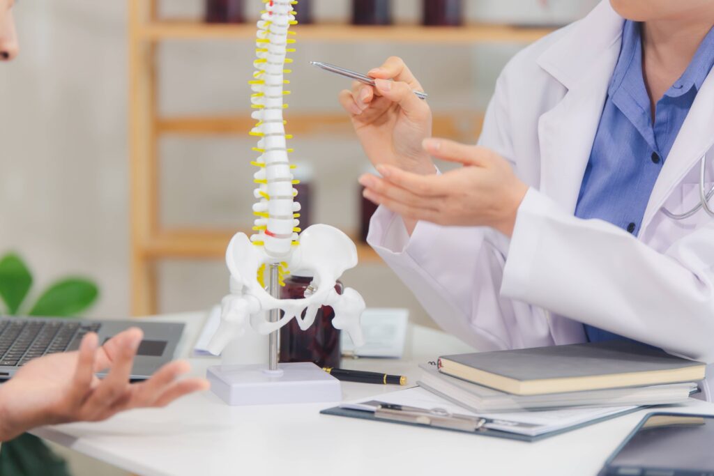 Orthopedists pointing at spine model