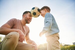 father and son playing football