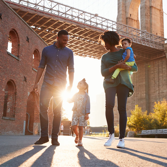 Young family with two daughters walk on a street