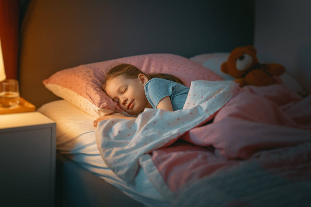 Adorable little child is sleeping in the bed