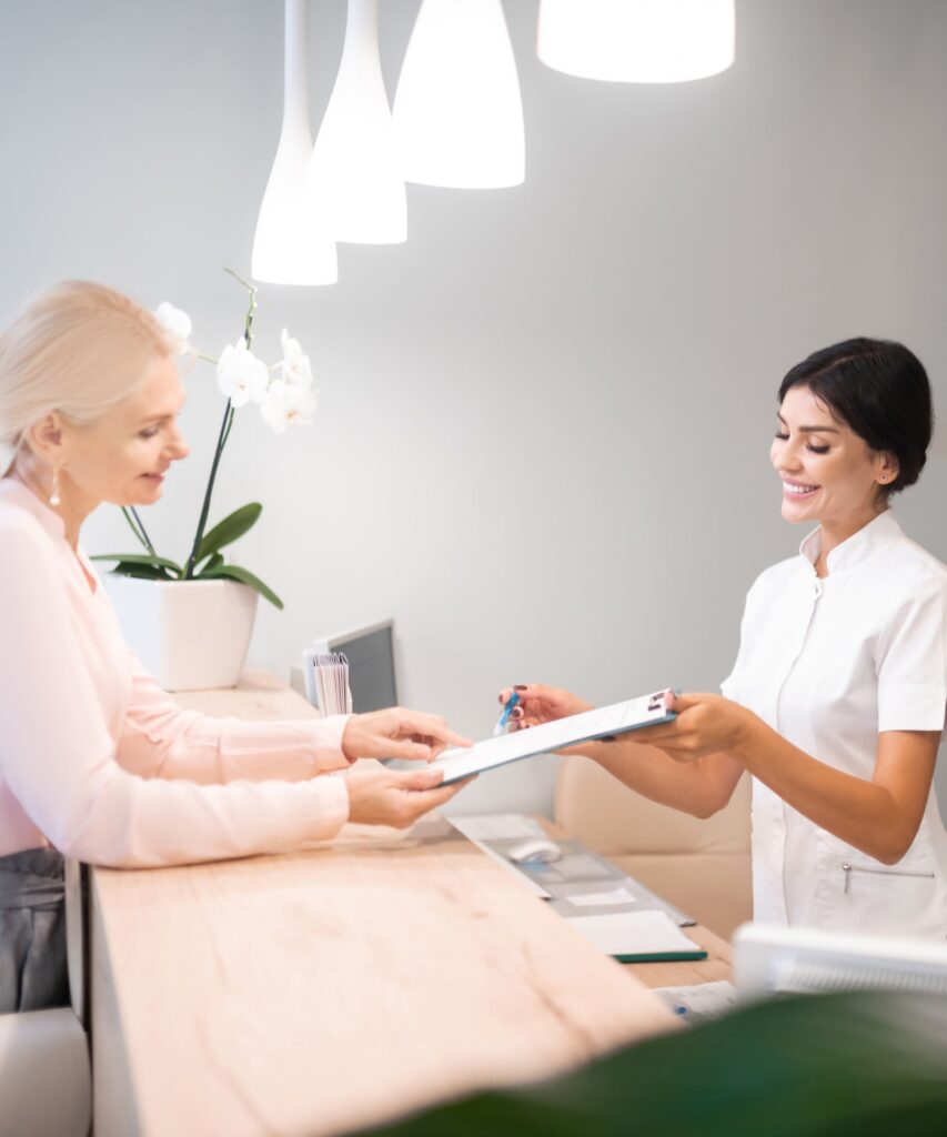 Cheerful administrator standing at reception desk