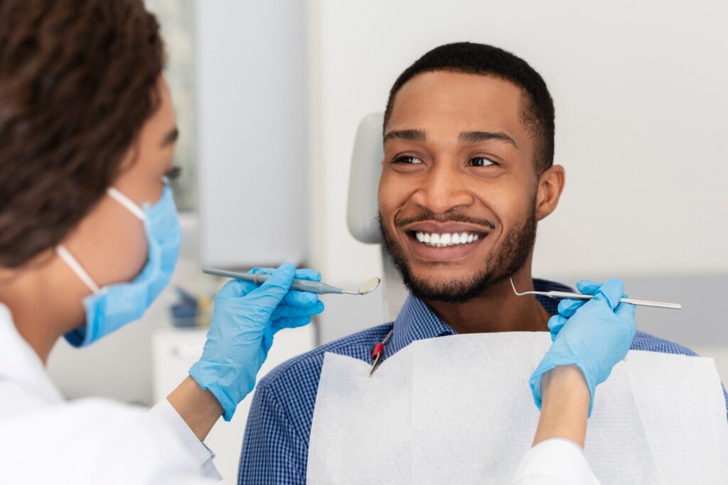 Smiling african guy in dentist chair