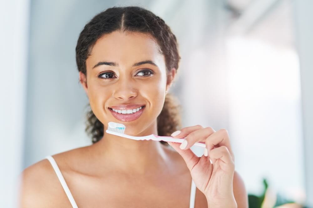 woman with toothbrush in home for dental hygiene