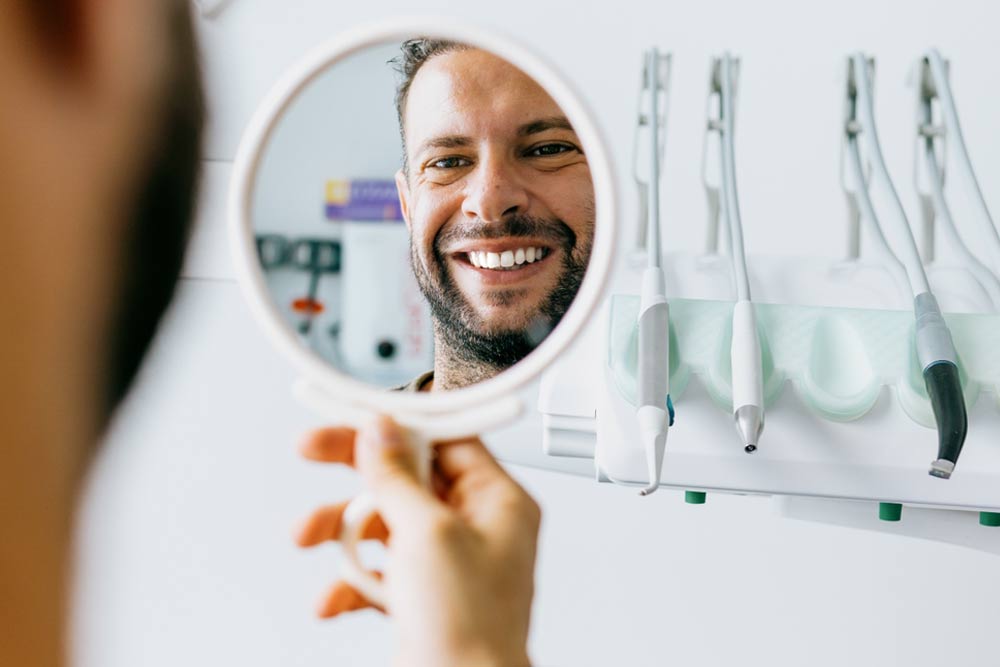 Satisfied man looks in the mirror and smiles