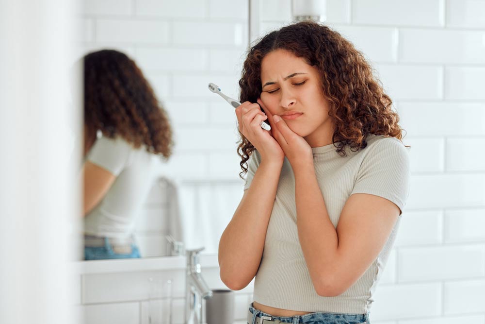 Young female with a cavity suffering from discomfort