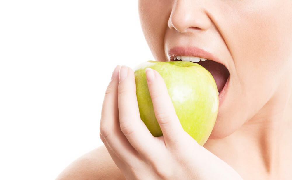 woman eating a green apple