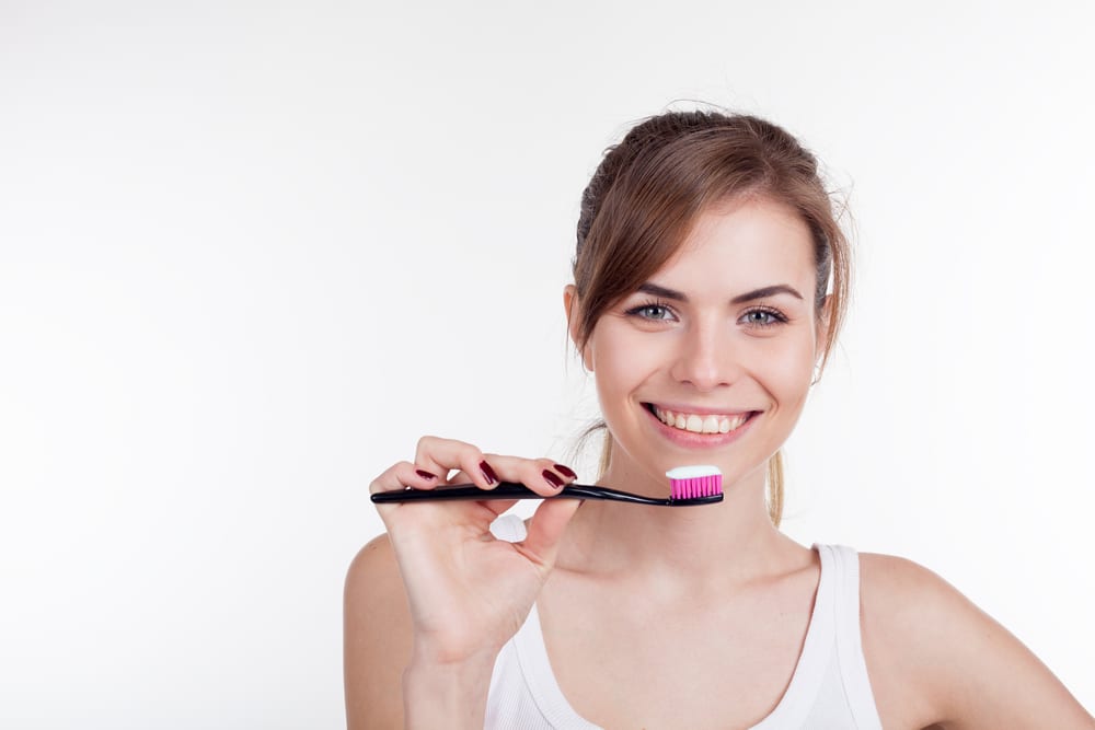 girl holding a toothbrush with smile