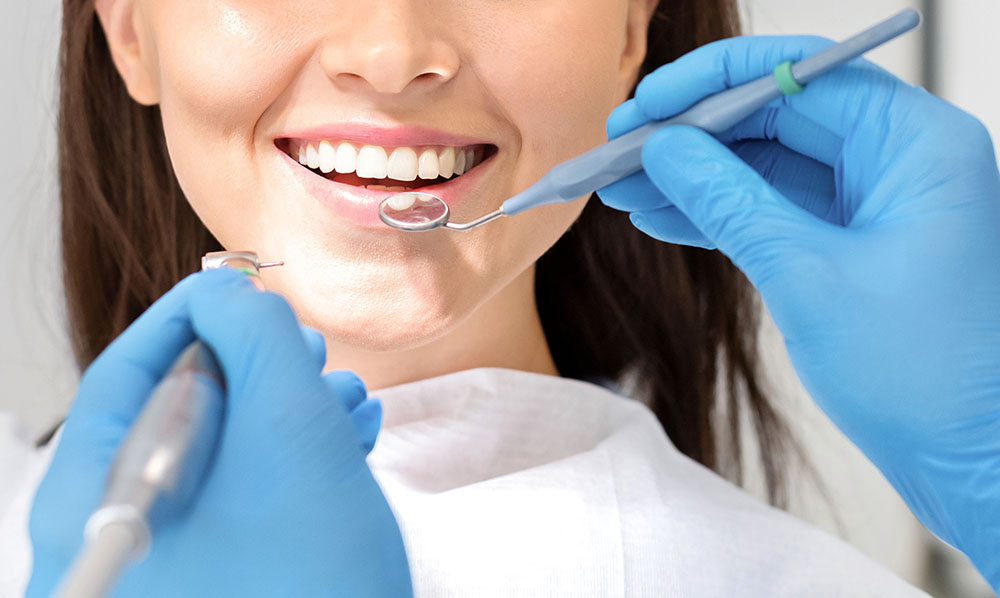 smiling woman mouth under treatment at dental clinic