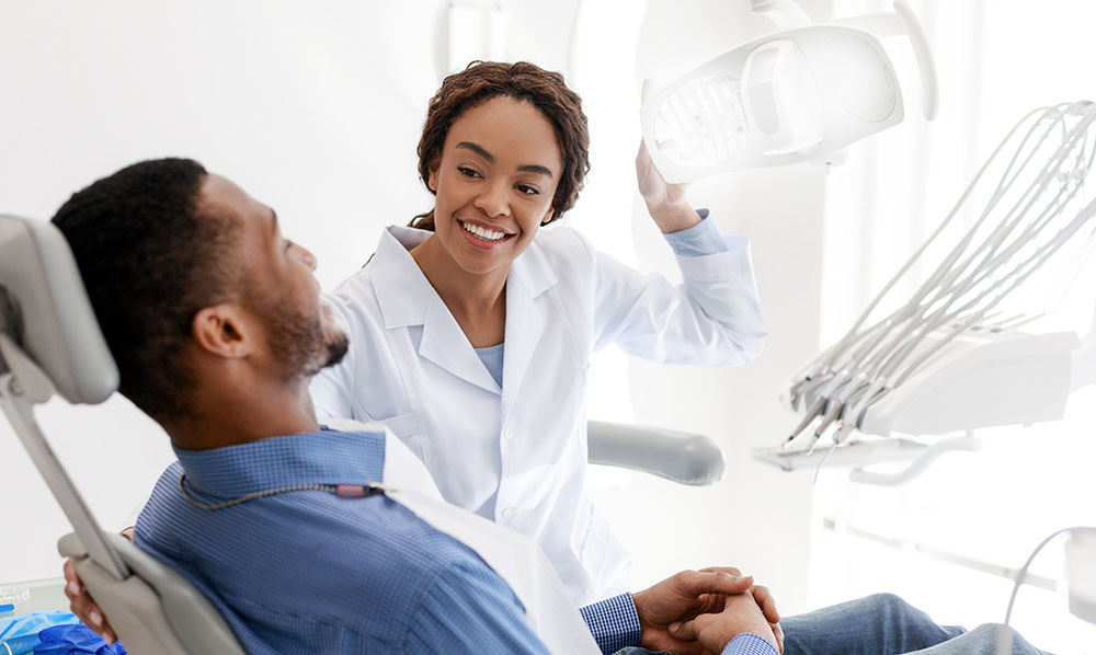 female dentist turning on lamp before treatment