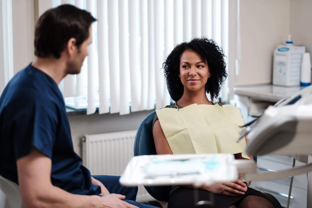 A dentist explaining the options for a broken root canal tooth and if it’s an emergency with a patient.
