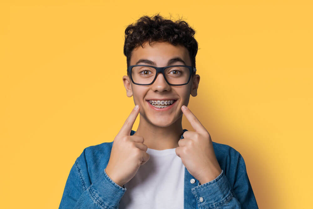 сurly haired young man wear metal braces