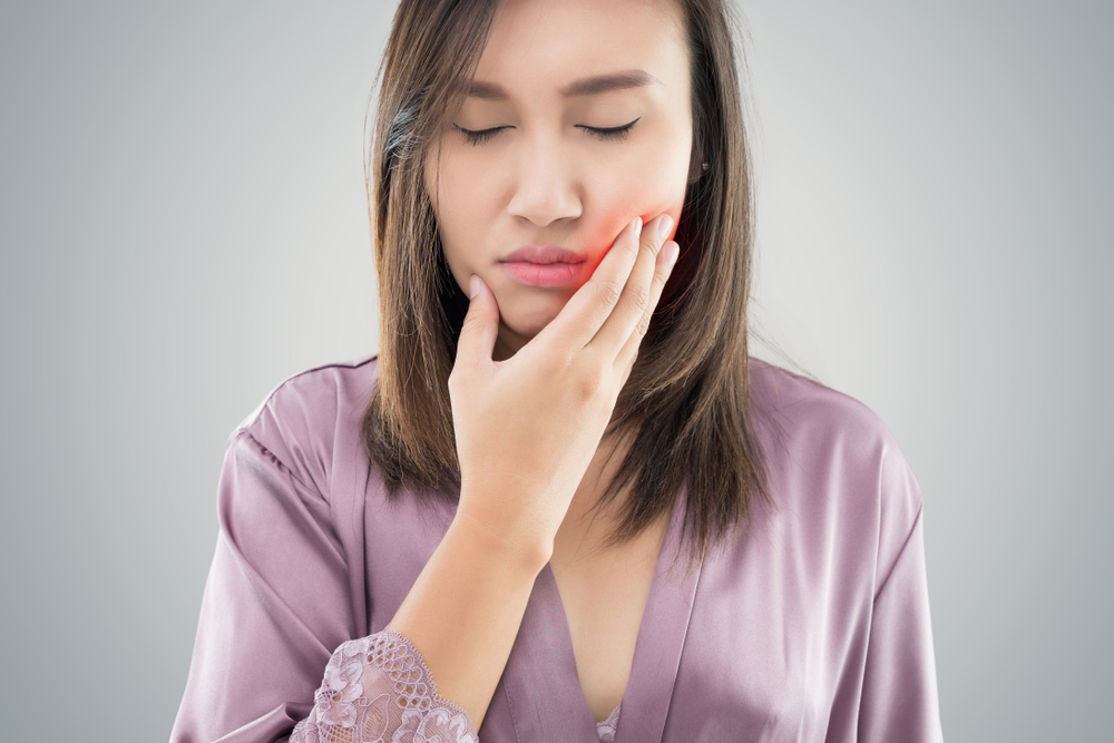 Beautiful young woman suffering from toothache