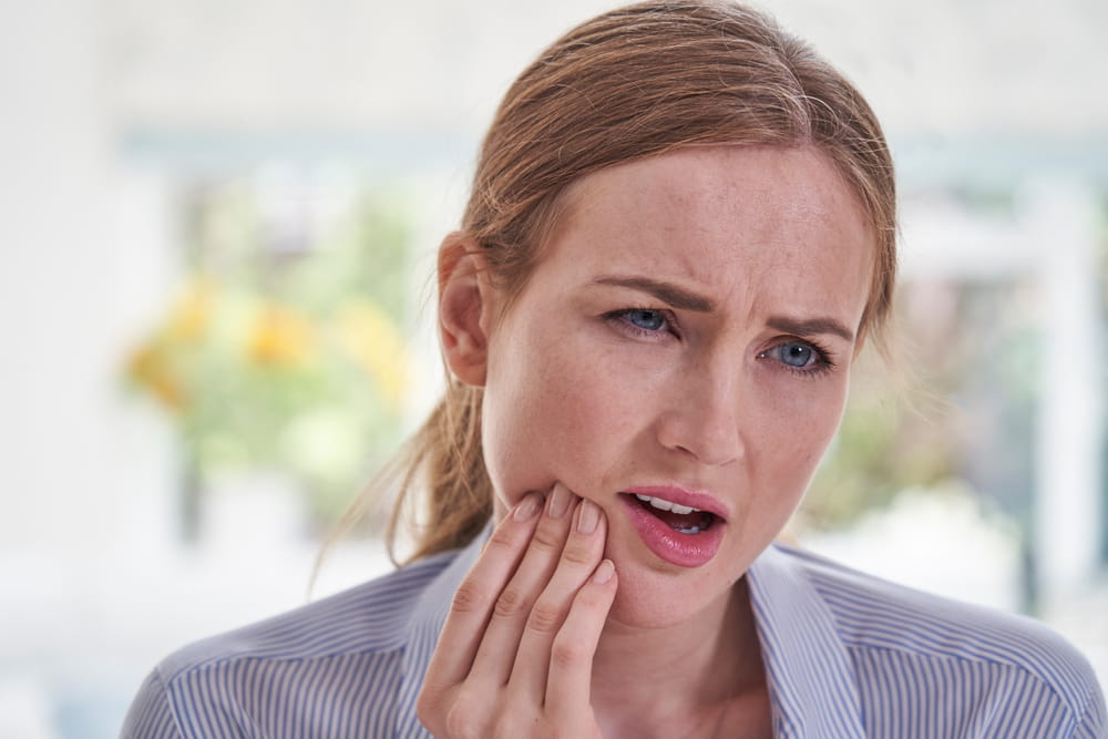 Young Woman Suffering With Toothache Touching Jaw