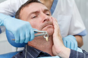 Dentist has extracted a sick tooth from patient in dental office.