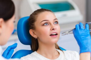 Tooth extraction beautiful girl in dentistry.