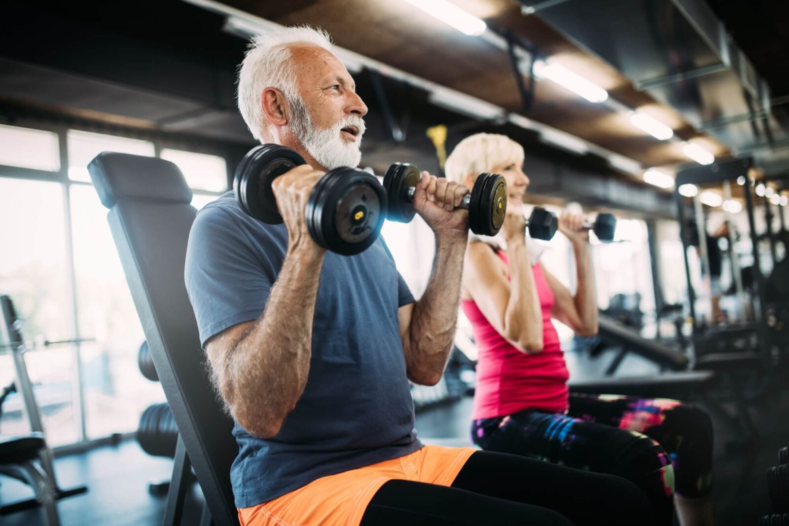 Happy senior people doing exercises in gym