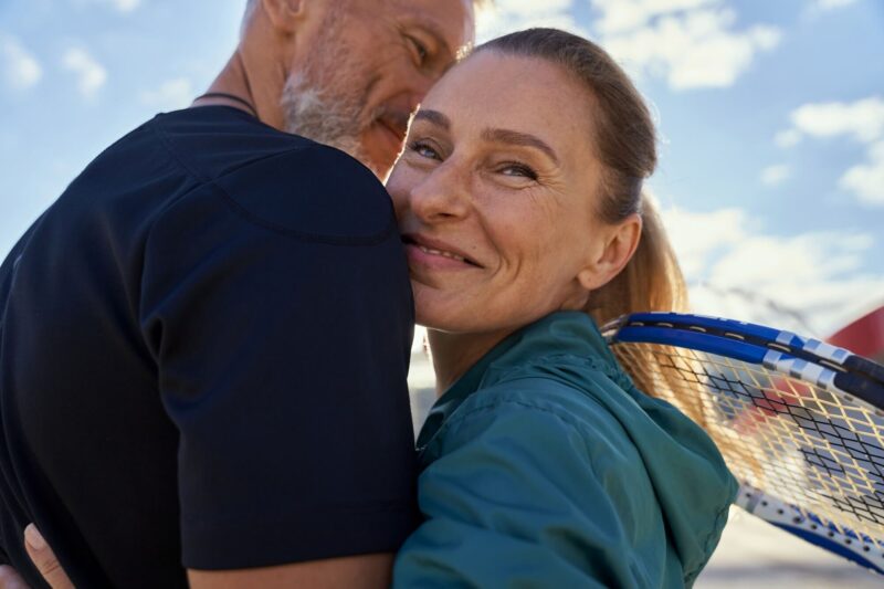 active mature couple looking happy while embracing each other outdoors