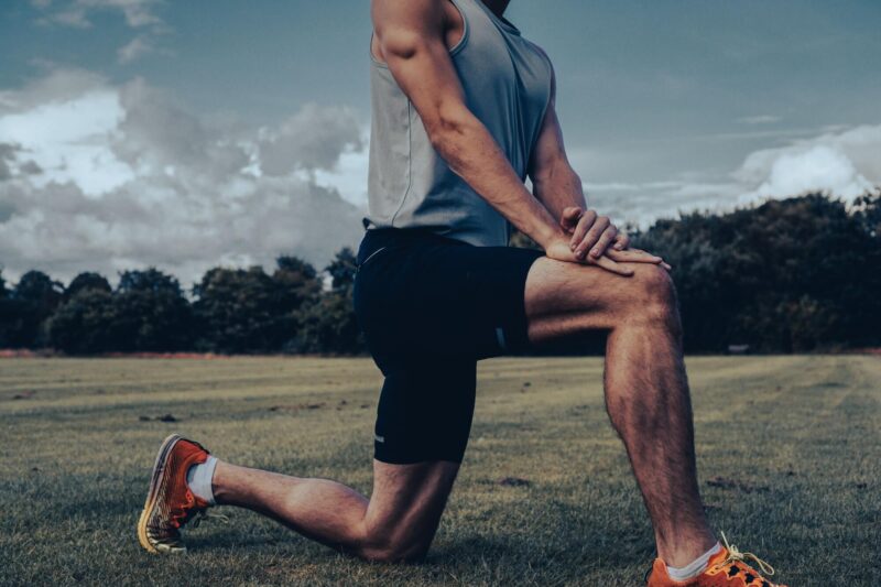 Muscular athlete stretching hamstring and hip flexor in a yoga position