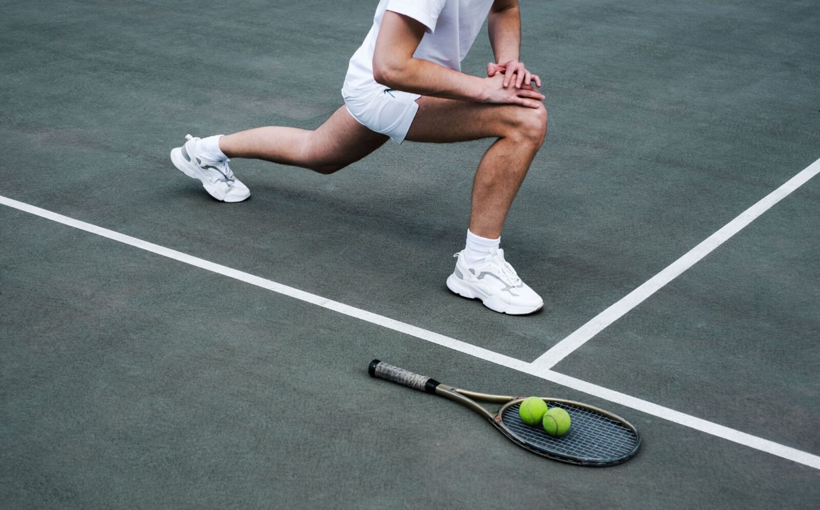 young man doing a warm-up on the sports ground before playing tennis