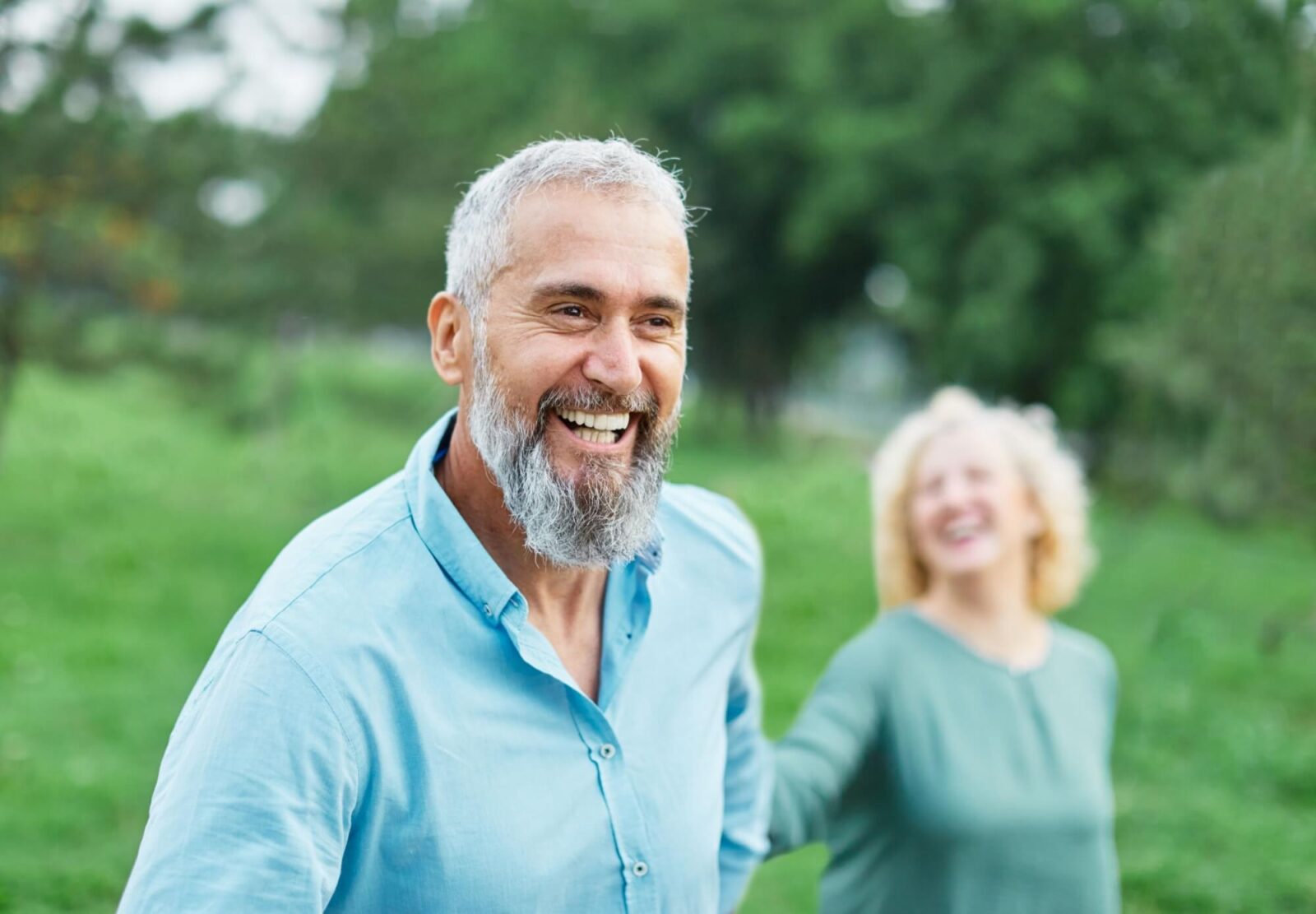 Happy active mid aged couple having fun walking