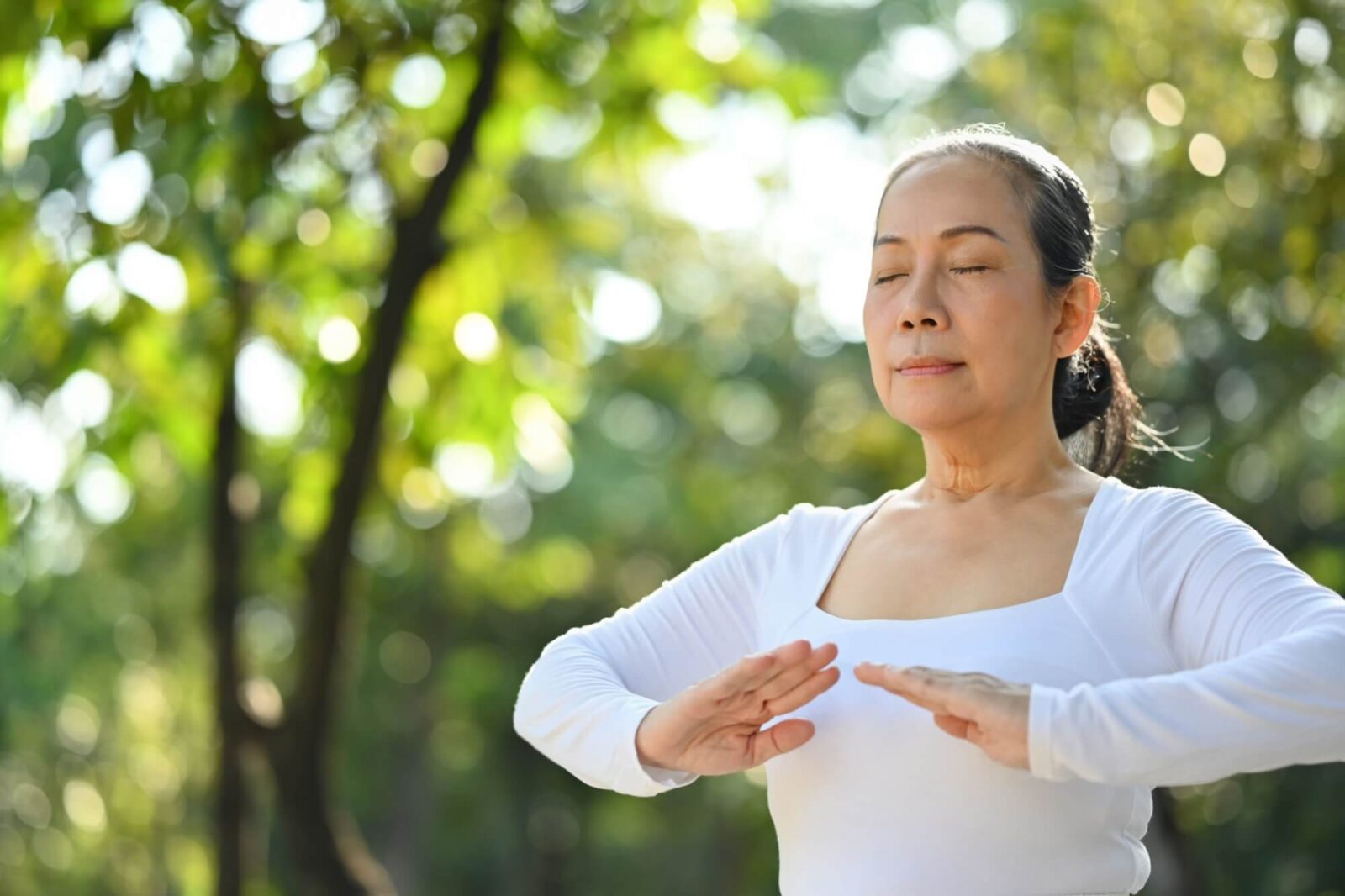 Calm senior woman with eyes closed meditating