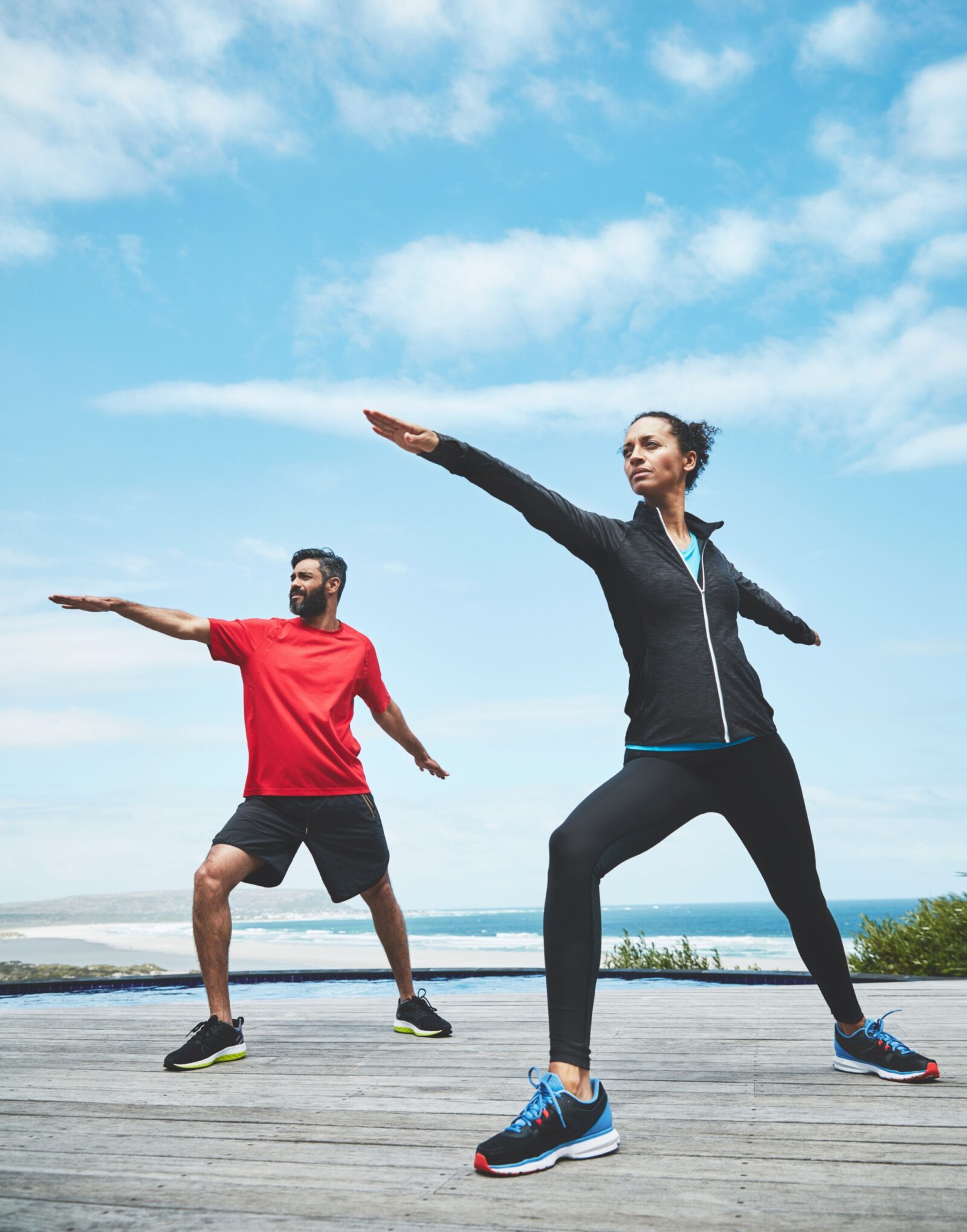 Couple stretching arms for yoga in nature