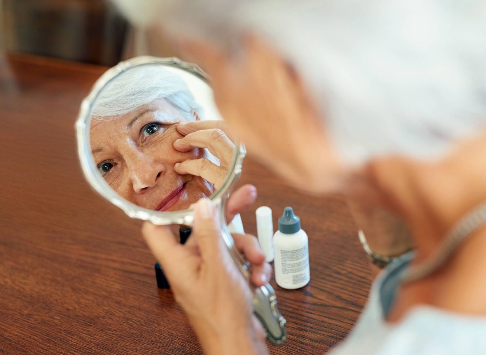 Senior woman checking face with hand gesture