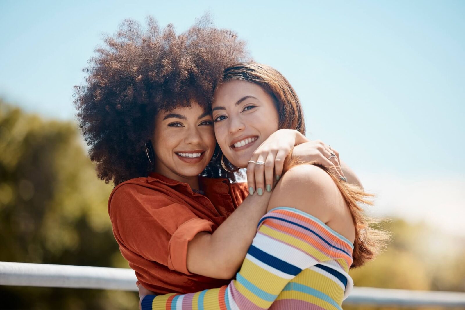 Happy women embrace and hugging each other on balcony