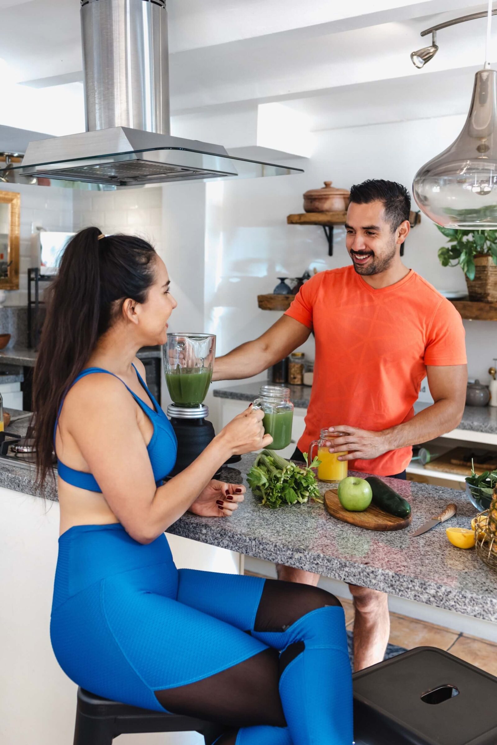 fitness couple drinking green juice and eating healthy food