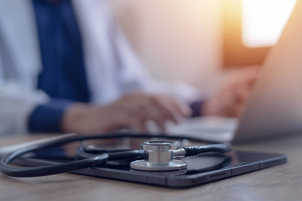 Close-up of doctor working on laptop computer