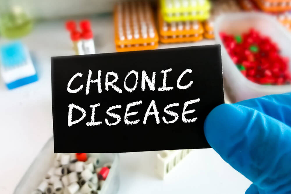 Doctor holding a card with term chronic disease