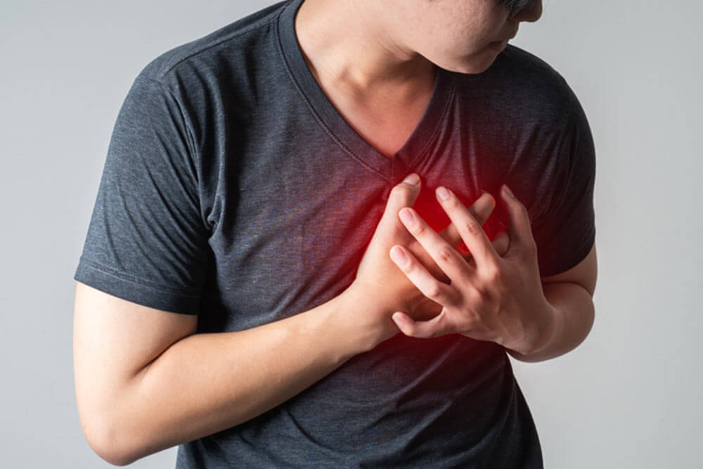 man pressing on chest with painful expression