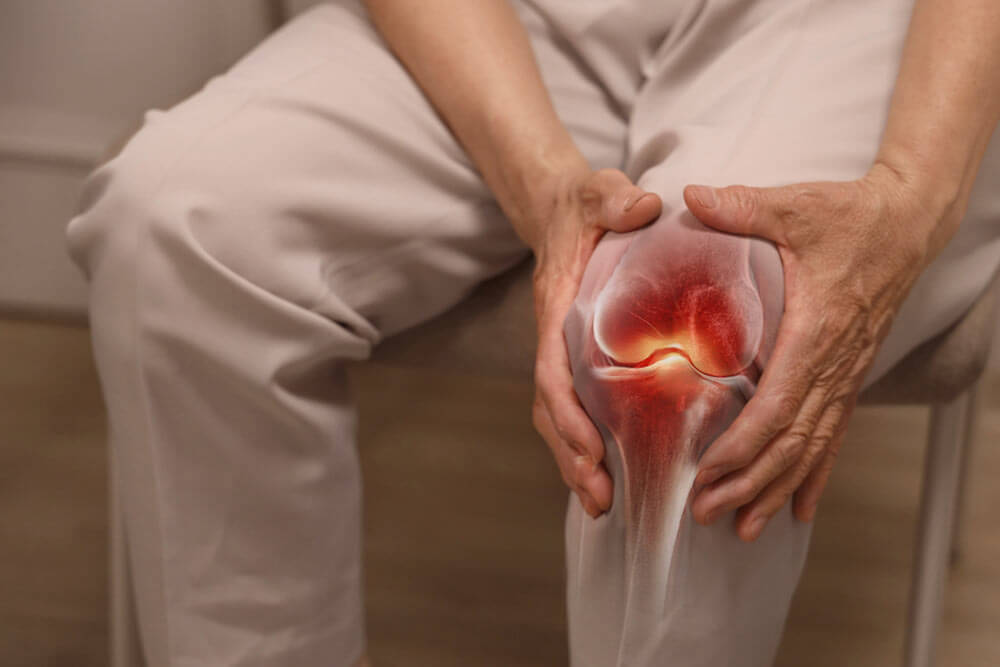 Close-up of an elderly woman holding her knee