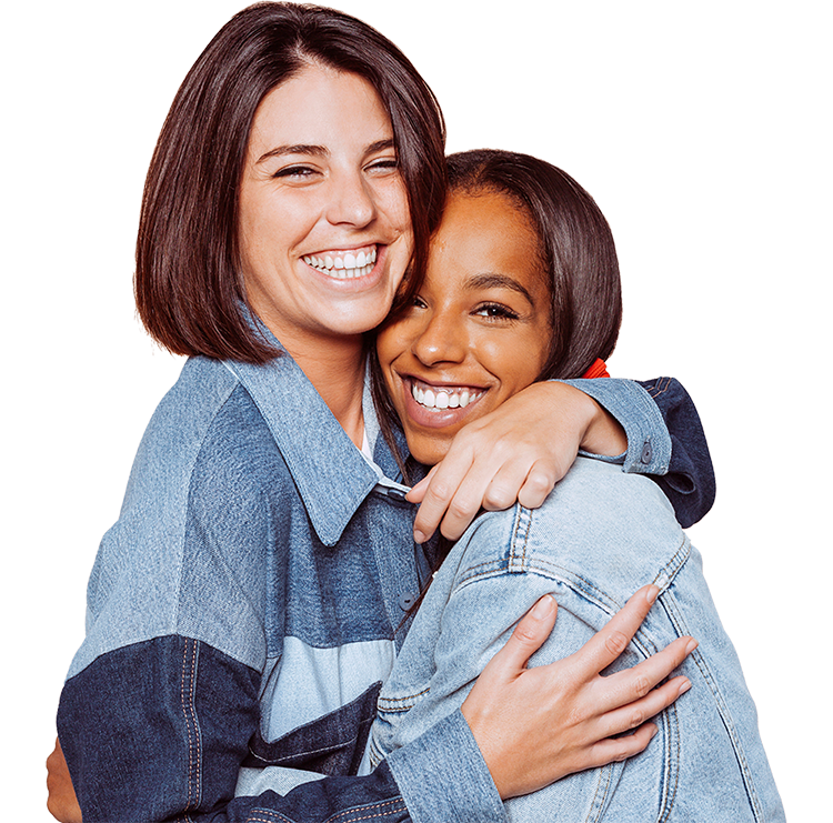 two cheerful girls hugging and smiling together